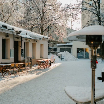 Snowy courtyard of Kashtan Coffee with outdoor tables in Kyiv