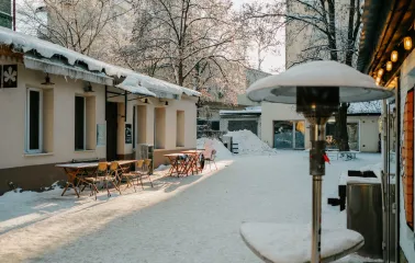 Snowy courtyard of Kashtan Coffee with outdoor tables in Kyiv