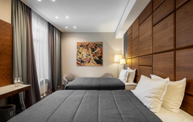 City Hotel in Kyiv - hotel room with two twin beds, wooden wall panel and painting