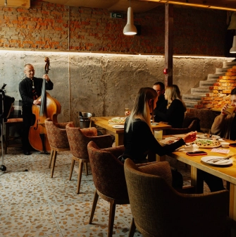 Restaurant Tisto, Syr i Titka Bella - live music performance near dining tables in a rustic room