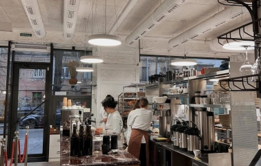 Spelta - baker working in the open kitchen preparing dough near the oven