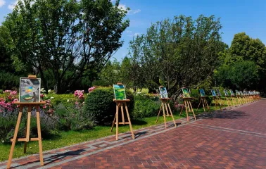 Paintings on easels displayed along a pathway in the park of the Mezhyhirya Residence