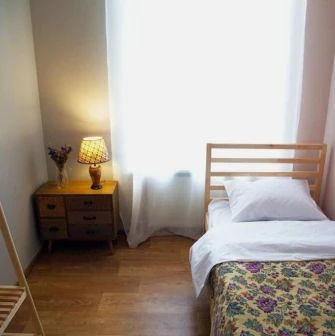 Single room with a wooden bed at Kashtan Guest House in Kyiv