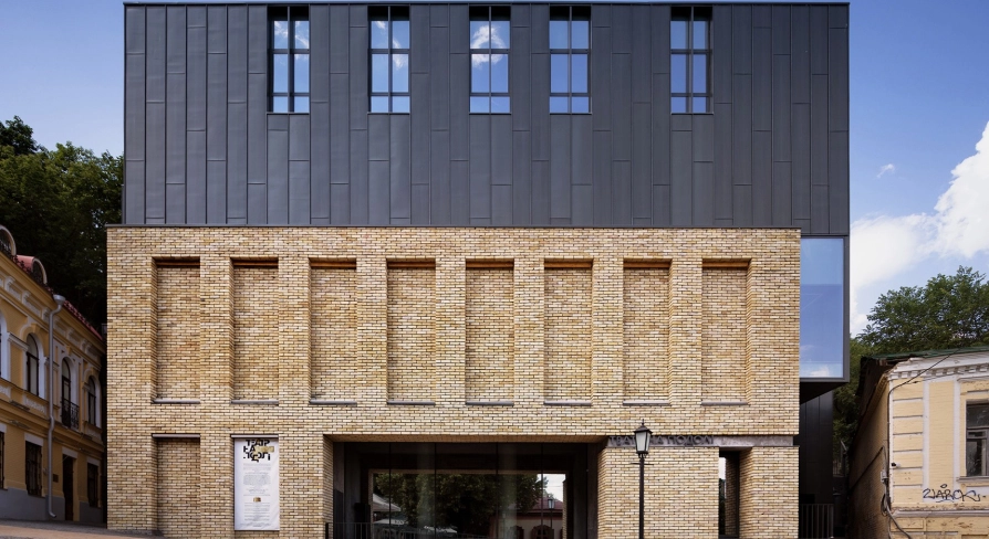 Teatr na Podoli in Kyiv - striking modern architecture of the theater featuring a dark metal upper facade and yellow brick base