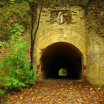 Lysa Hora in Kyiv - view through an old brick tunnel archway surrounded by autumn leaves