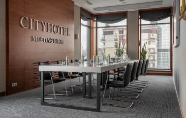 City Hotel in Kyiv - meeting room with long white table, black chairs and wooden wall