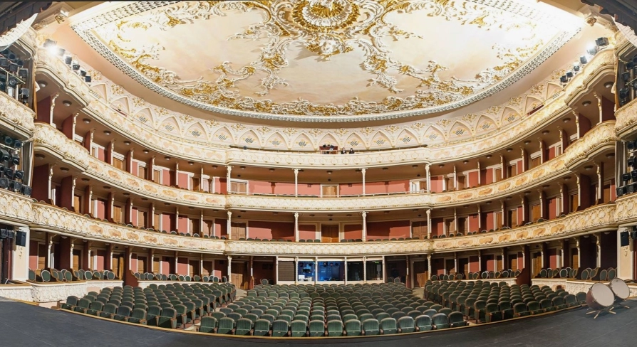 Teatr Franka in Kyiv - majestic panoramic view of the empty theater hall showcasing the painted ceiling, gold decorations, and rows of velvet seats