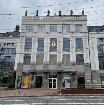 Muzei Istorii Mista Kyieva in Kyiv - modern white facade of the museum building featuring a large clock and statues on the roof