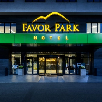 The entrance to the Favor Park hotel in Kyiv with an illuminated sign and a modern facade