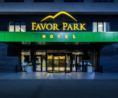 The entrance to the Favor Park hotel in Kyiv with an illuminated sign and a modern facade