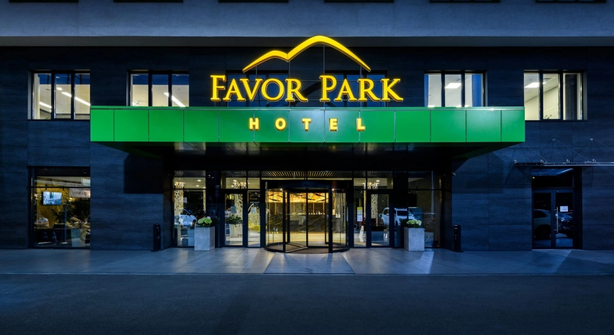 The entrance to the Favor Park hotel in Kyiv with an illuminated sign and a modern facade