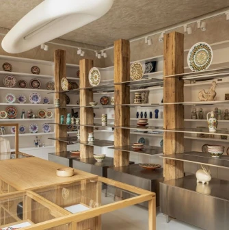 Narodnyi Dim Ukraina in Kyiv - elegant shopping space with wooden beams displaying ceramic plates and traditional clothing