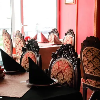 Festively set tables with red tablecloths and carved chairs