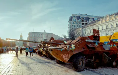 Mykhailivska Square in Kyiv - people gathered around a row of rusty destroyed tanks