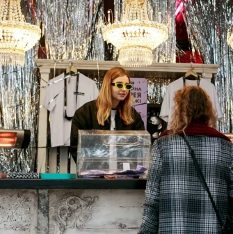 Seller of a bright glam stand with chandeliers at the Kurazh market in Kyiv