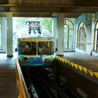 Kyiv Funicular - blue carriage at the station next to stained glass windows