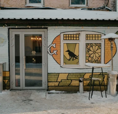 Entrance to OG Burger with street art and a snowy terrace in Kyiv