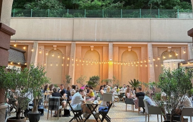 Restaurant Italiets iz Beiruta - view through an arch of the outdoor dining patio with strung lights