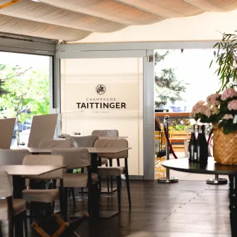Світла тераса ресторану Lucky з брендованим оформленням Champagne Taittinger