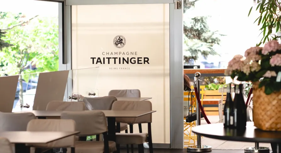 Світла тераса ресторану Lucky з брендованим оформленням Champagne Taittinger