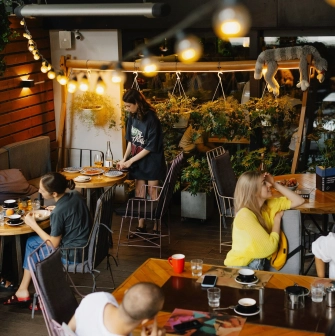 Restaurant Ulyublenyi Diadia - outdoor terrace with warm lights and customers dining