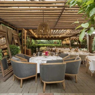 Elegant outdoor dining area with round tables and comfortable grey chairs