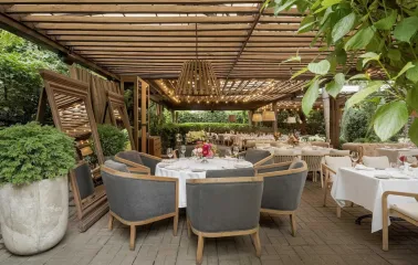 Elegant outdoor dining area with round tables and comfortable grey chairs