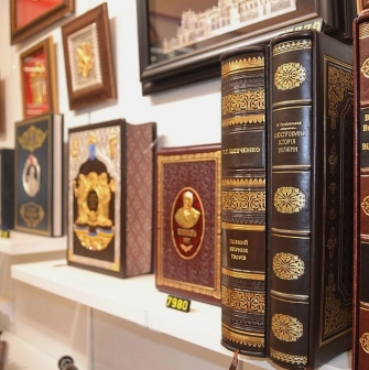 Folkmart in Kyiv - close-up of leather-bound gift editions of Ukrainian history books with gold leaf details
