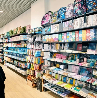 UAmade in Kyiv - store aisle where stylish backpacks are presented on the upper shelves, and various stationery items are presented below