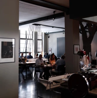 Elegant restaurant interior with dark lighting and guests at their tables