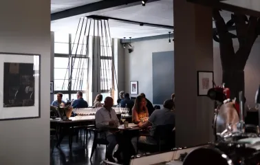 Elegant restaurant interior with dark lighting and guests at their tables