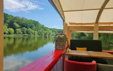 Restaurant Kukhnya Polli - lake view from an open terrace with decorative railings and flower pots