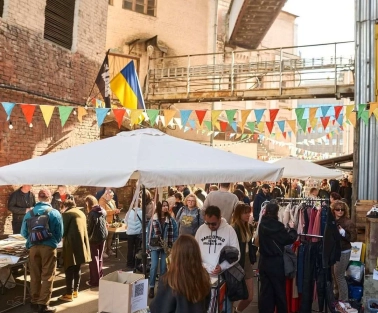 The Podilsky Shuk vintage street market in Podil with clothes, the Ukrainian flag, and visitors