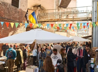 The Podilsky Shuk vintage street market in Podil with clothes, the Ukrainian flag, and visitors