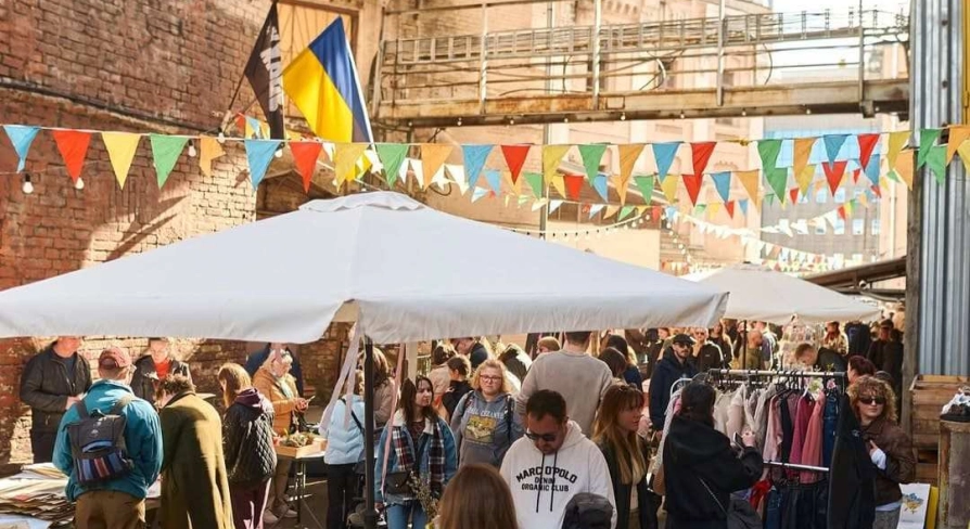 The Podilsky Shuk vintage street market in Podil with clothes, the Ukrainian flag, and visitors