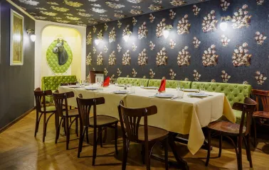 Restaurant Za Dvoma Zaicyamy - private dining room with long table green velvet seats and wall decor