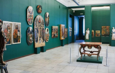 Natsionalnyi Khudozhnii Muzei Ukrainy in Kyiv - spacious gallery hall with green walls displaying ancient religious icons and a carved wooden table