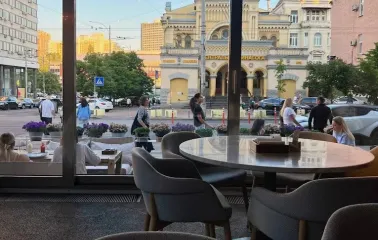Bright modern hall of the Holy Burger restaurant in Kyiv with wooden tables