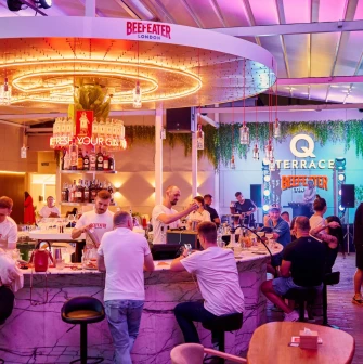 Q Terrace is a long, modern bar with a prominent display of various drinks