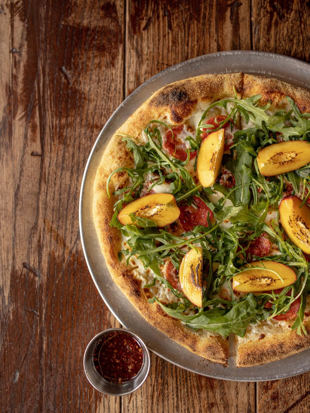 Pizza with peaches, arugula, and sauce at Mimosa Brooklyn Pizza