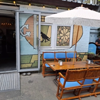 OG Burger in Kyiv - terrace with wooden tables and white umbrella
