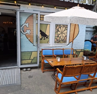 OG Burger in Kyiv - terrace with wooden tables and white umbrella