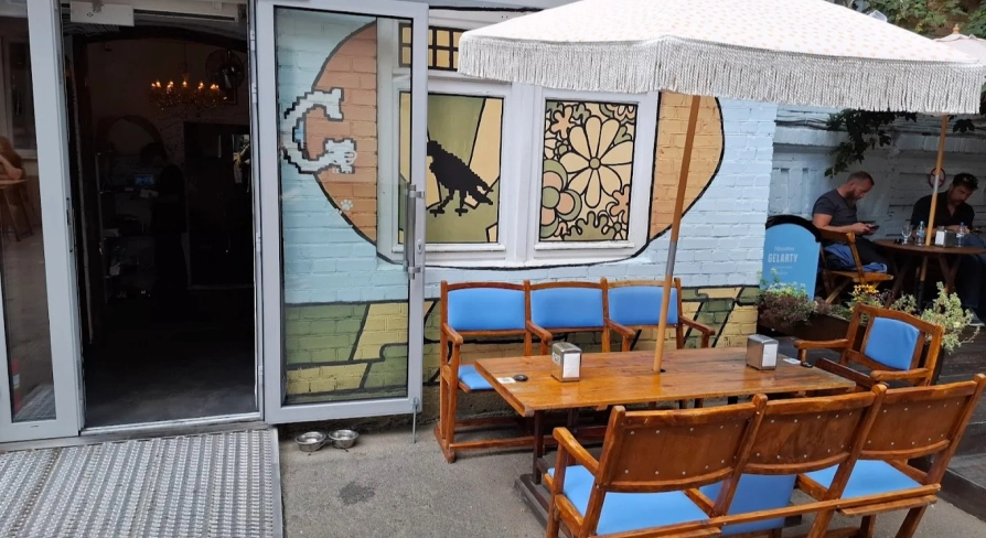 OG Burger in Kyiv - terrace with wooden tables and white umbrella