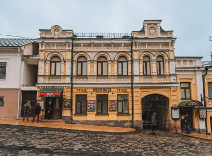 Koleso Theater in Kyiv - full view of historic yellow building on cobbled street