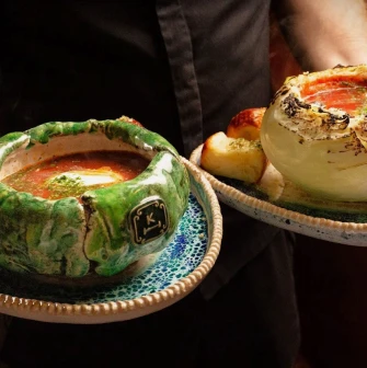 Restaurant Kanapa - waiter holding two artistic dishes with borscht