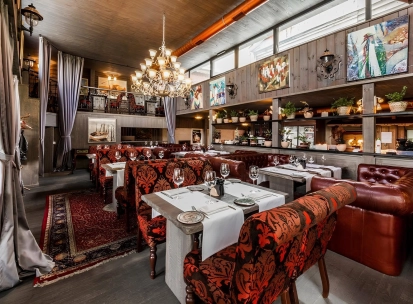 Restaurant Kanapa - dining room with tables leather couches and paintings on the wooden walls