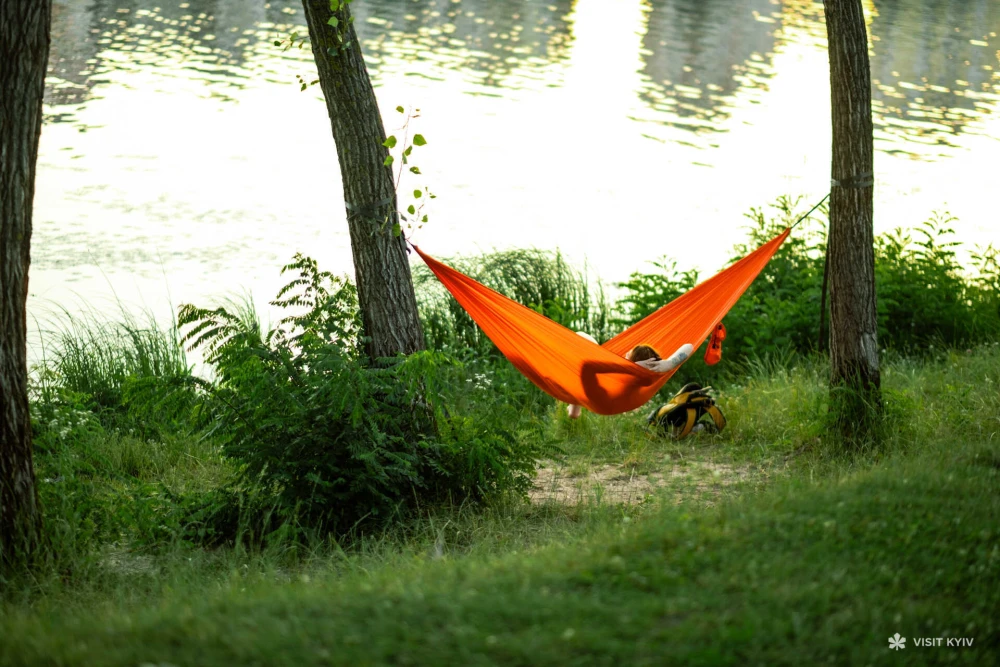 A person rests in a hammock on the Obolon embankment