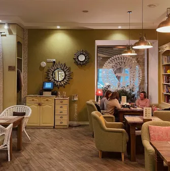 Restaurant Imbyr - relaxed dining room with armchairs bookshelves and people sitting at tables