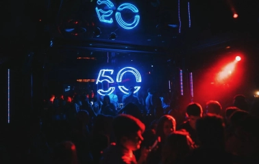 Fifty Club - neon 50 sign glowing above crowd in dark club