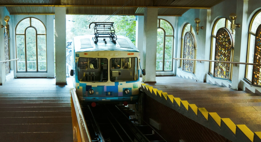 Kyiv Funicular - blue carriage at the station next to stained glass windows